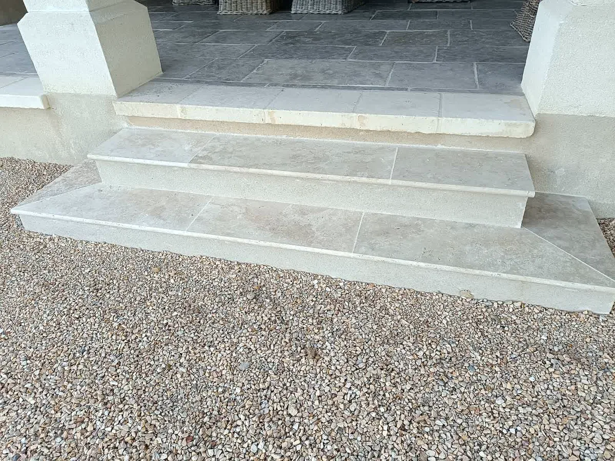 Escalier d'entrée fini en pierre grise sur cour en gravier
