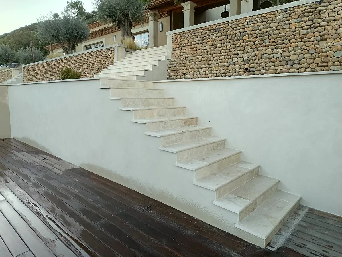 Escalier extérieur maçonné le long d'un mur en galets