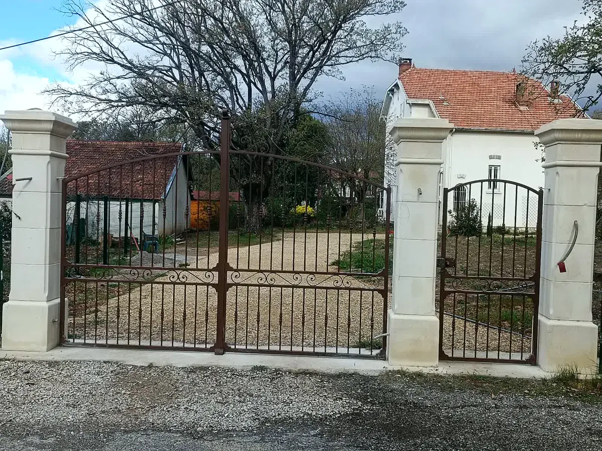 Piliers de portail maçonnés avec portail en fer forgé