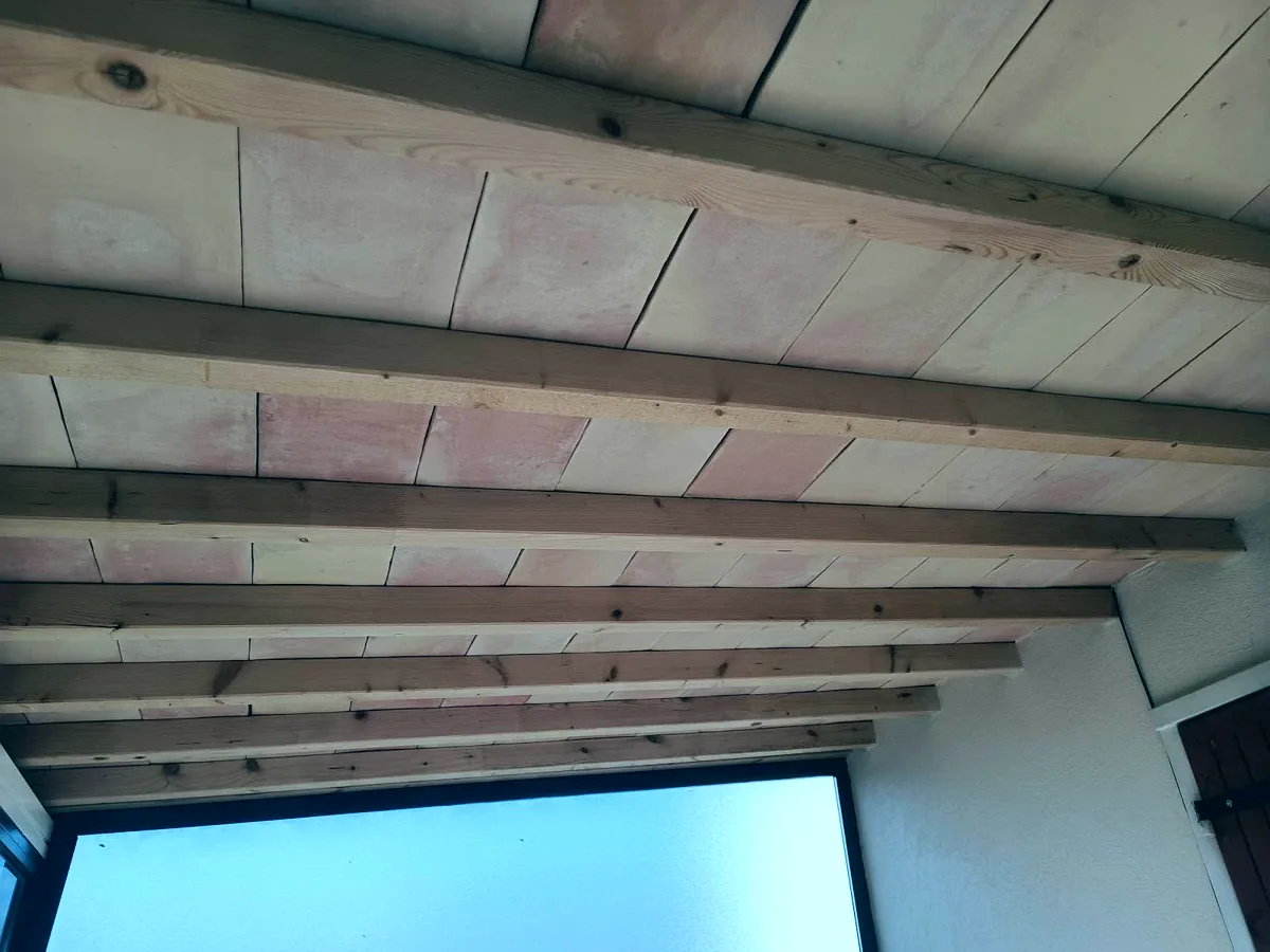 Plafond rénové avec poutres en bois apparentes